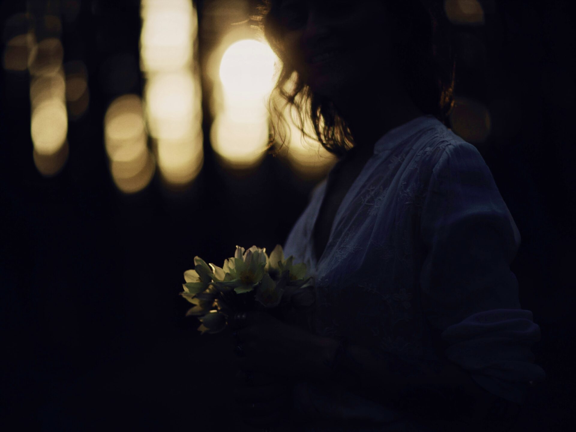 Person holding flowers dark
